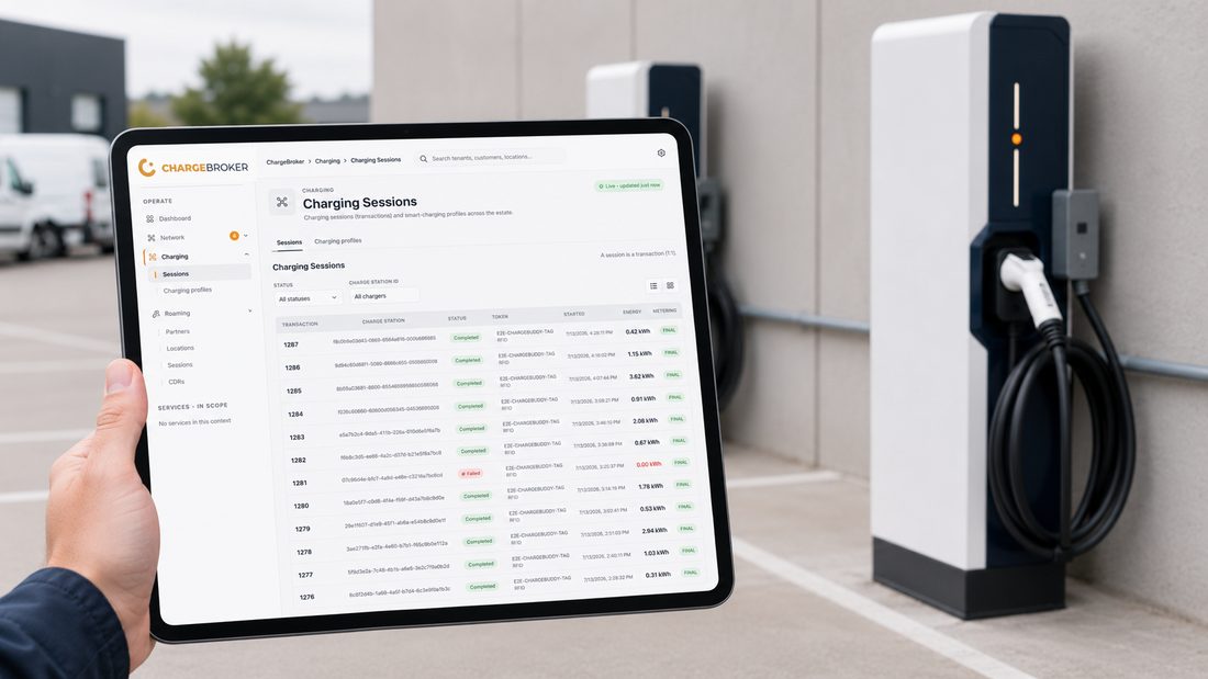 ChargeBroker Sessions view on a tablet held up in front of live EV chargers, showing transaction history and energy delivered